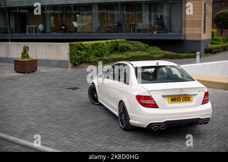 La Mercedes Benz 2014 C63 AMG Saloon W204 a terminé en blanc diamant lors D'Une soirée ensoleillée à Manchester Banque D'Images