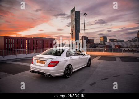 La Mercedes Benz 2014 C63 AMG Saloon W204 a terminé en blanc diamant lors D'Une soirée ensoleillée à Manchester Banque D'Images