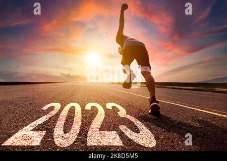 Jeune homme courant et sprinting sur la route avec le nouveau concept de l'an 2023 Banque D'Images