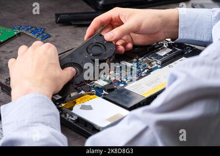 Mains de fixation de la carte mère de pc ou ordinateur portable en gros plan en service. Service de réparation d'ordinateur portable. Banque D'Images