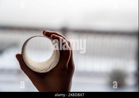 Enfant tenant un tube de papier de toilette en carton comme un télescope pour voir à travers pour imaginer un autre monde Banque D'Images