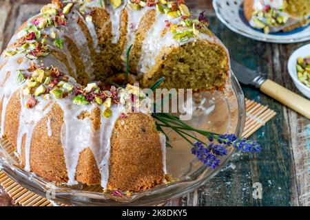 Gâteau parfumé d'amour perse décoré avec du glaçage à la vanille, des pistaches écrasées et des pétales de rose séchés Banque D'Images