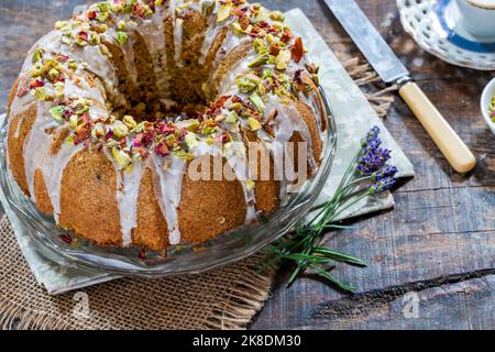 Gâteau parfumé d'amour perse décoré avec du glaçage à la vanille, des pistaches écrasées et des pétales de rose séchés Banque D'Images