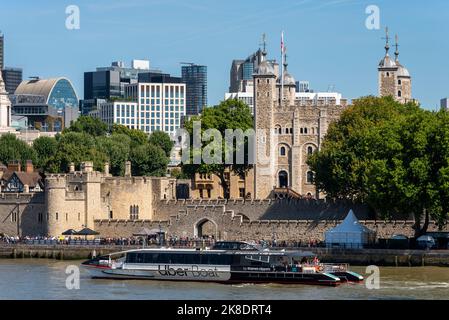 Uber Boat bateau-bus sur la Tamise en passant par la Tour de Londres, Royaume-Uni. Service de bateau-taxi. Tour blanche et murs Banque D'Images