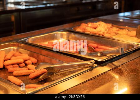 Buffet - plats sur plateaux chauds - doigts de poisson, saucisses et petits pains. Restauration rapide. Banque D'Images