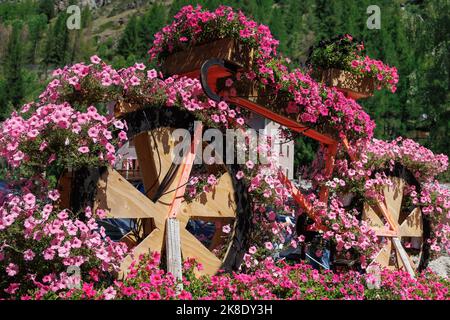 Sculpture décorative en bois d'un vélo de course entièrement recouvert de fleurs roses. Banque D'Images