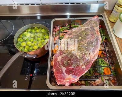 Branche d'agneau crue dans un plat à rôtir avec légumes et épices. Hesse, Allemagne Banque D'Images