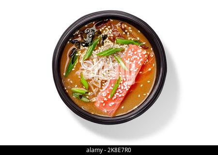 Soupe crémeuse de saumon miso avec pâte blanche miso, alaria séchée, shiitake, nouilles de riz, échalotes hachées et sésame Banque D'Images