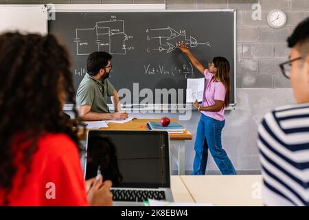 Jeune étudiante hispanique latine expliquant le projet à l'école secondaire Banque D'Images