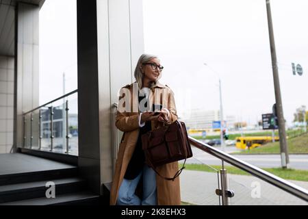 une avocate de 50 ans attend un client pour une réunion près du centre d'affaires Banque D'Images