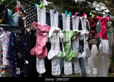 Une rangée de couches en tissu coloré sèche sur une ligne de lavage. Banque D'Images