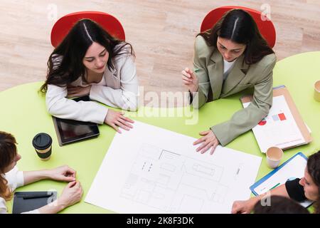 Équipe d'affaires ayant une réunion à table dans la salle de conférence discutant du plan de la surface de vente Banque D'Images