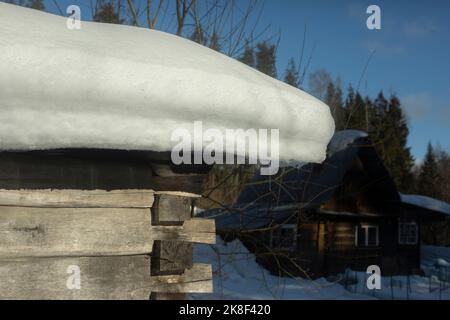 Neige sur le toit de la grange en bois. Ferme. Hiver dans le village. Ancienne maison en planches. Banque D'Images