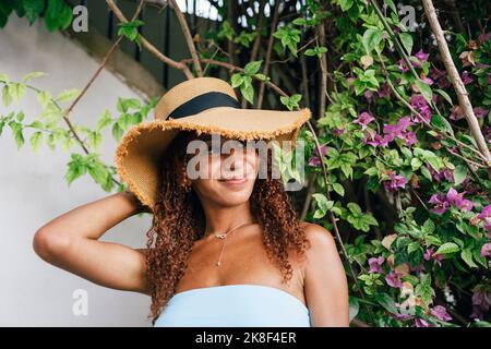 Femme souriante portant un chapeau devant l'usine Banque D'Images