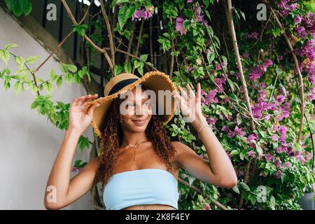 Jeune femme souriante portant un chapeau devant l'usine Banque D'Images