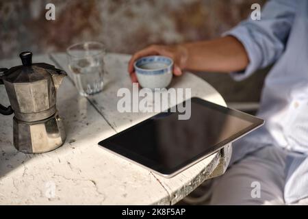 Tablette PC près d'une cafetière sur la table Banque D'Images