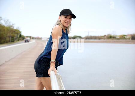 Bonne femme âgée penchée sur une rampe Banque D'Images