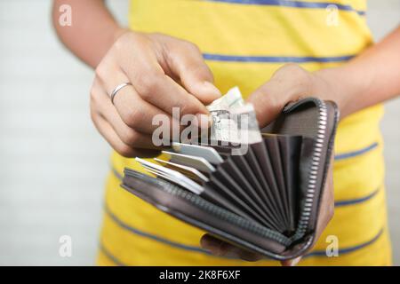 les jeunes hommes prennent de l'argent dans leur portefeuille Banque D'Images