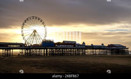 Blackpool Pier avec sa grande roue et le coucher de soleil derrière la roue le mettant en ligne dans la silhouette Banque D'Images