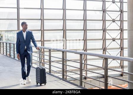 Un jeune homme d'affaires se promenant sur une rampe sur le pont à la gare Banque D'Images