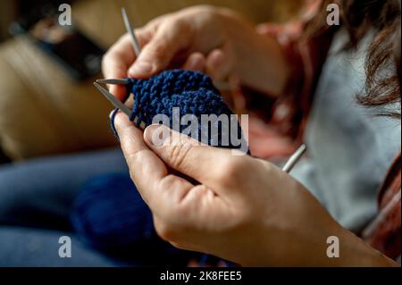 Femme triant avec de la laine bleue à la maison Banque D'Images