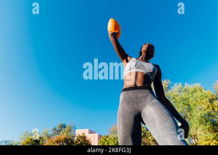 Un joueur américain de football lance une balle par beau temps Banque D'Images