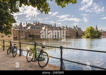 Pays-Bas, pays-Bas du Sud, la Haye, bicyclettes penchées sur une rampe de pont s'étendant sur le canal du lac Hofvijver avec le bureau du gouvernement de Binnenhof en arrière-plan Banque D'Images