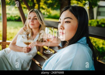 Femme attentionnés assise sur le porche balançoire par un ami le week-end Banque D'Images