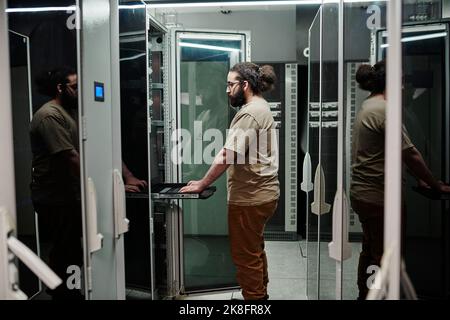 Technicien informatique travaillant dans la salle des serveurs Banque D'Images