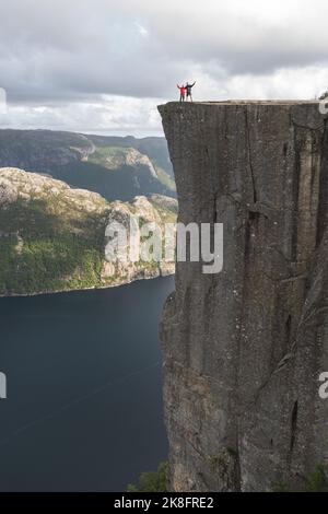 Randonneurs debout sur le bord de la falaise de Pulpit par le fjord Lysefjorden, Norvège Banque D'Images