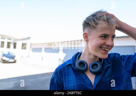 Un garçon adolescent heureux avec la tête à la main Banque D'Images