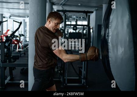 Entraînement de boxeur professionnel jeune avec sac de poinçonnage Banque D'Images