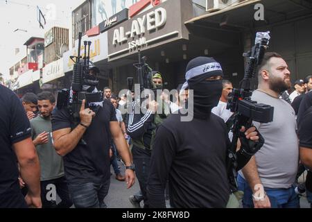 Naplouse, Palestine. 23rd octobre 2022. Des hommes armés assistent aux funérailles d'un activiste palestinien, Tamer al-Kilani, membre fondateur du groupe armé Lions Den dans la vieille ville de Naplouse, en Cisjordanie. Al-Kilani a été tué après l'explosion de sa moto. Les habitants de la région ont déclaré que la moto était piégée par des huées pour assassiner Al-Kilani. Crédit : SOPA Images Limited/Alamy Live News Banque D'Images