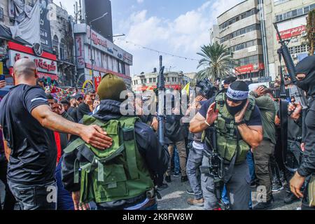 Naplouse, Palestine. 23rd octobre 2022. Des hommes armés assistent aux funérailles d'un activiste palestinien, Tamer al-Kilani, membre fondateur du groupe armé Lions Den dans la vieille ville de Naplouse, en Cisjordanie. Al-Kilani a été tué après l'explosion de sa moto. Les habitants de la région ont déclaré que la moto était piégée par des huées pour assassiner Al-Kilani. Crédit : SOPA Images Limited/Alamy Live News Banque D'Images