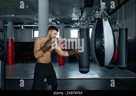 Entraînement de boxeur professionnel jeune avec sac de poinçonnage Banque D'Images