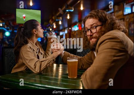 Défi de lutte de bras entre l'homme et la femme au pub Banque D'Images