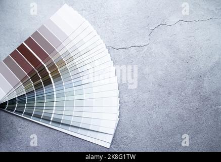 Échantillons de peinture nuance de couleurs pour le design intérieur. Fond gris en béton fissuré, couleurs terre. Banque D'Images