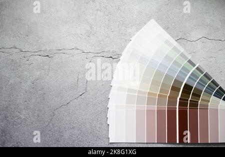 Échantillons de peinture nuance de couleurs pour le design intérieur. Fond gris en béton fissuré, couleurs terre. Banque D'Images