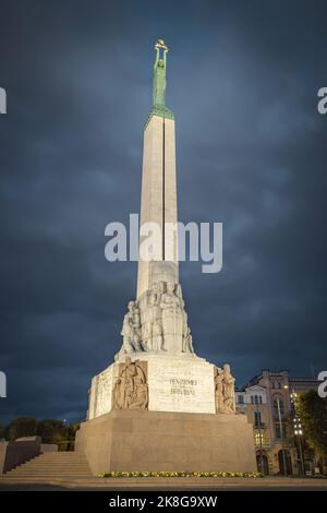 Monument de la liberté à Riga la nuit. Femme tenant trois étoiles d'or qui symbolisent trois régions de Lettonie. Banque D'Images