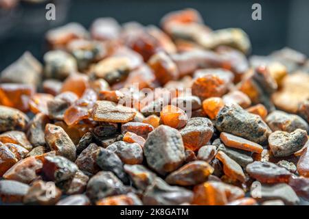 Ambre brut des rives de la mer Baltique. Des morceaux d'ambre brut se trouvent sur le verre noir. Matière première pour la production de bijoux. Banque D'Images