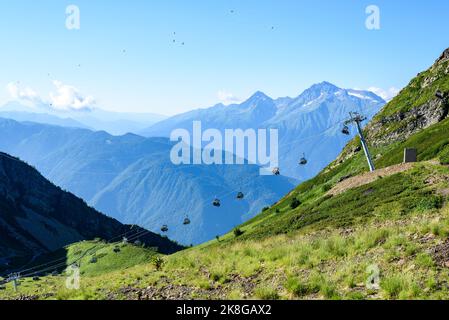 Téléphérique au milieu des montagnes avec des sommets enneigés par temps ensoleillé Banque D'Images