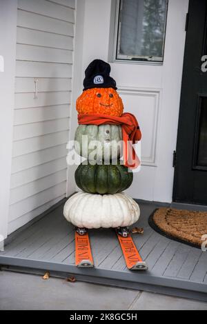 Bonhomme de neige citrouille sur skis sur un porche à Woodstock, Vermont, USA VT, US automne automne Halloween Nouvelle-Angleterre Banque D'Images