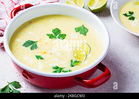 Soupe de maïs mexicaine avec fromage et herbes dans une casserole rouge. Concept de recette végétalienne. Banque D'Images