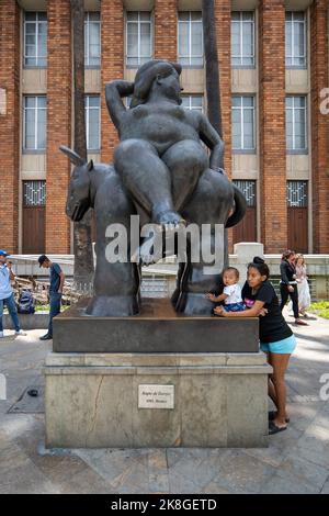 Medellin, Antioquia, Colombie - 12 septembre 2022 : une jeune femme tient un bébé sur une statue en bronze d'une grande femme de Fernando Botero à Famou Banque D'Images