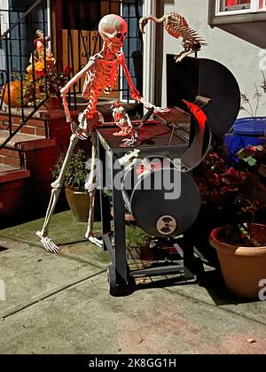 Squelette d'Halloween freaky ayant un barbecue dans la cour d'une maison sur une rue résidentielle à Brooklyn, New York. Banque D'Images