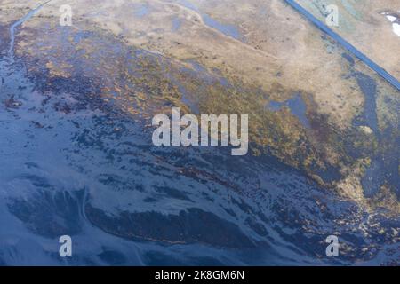 De dessus la route d'asphalte droite traversant la zone humide par temps froid d'hiver dans la campagne de l'Islande Banque D'Images