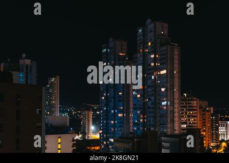 De grands blocs d'appartements avec fenêtres lumineuses situées contre le ciel nocturne sombre dans le quartier résidentiel de la ville Banque D'Images