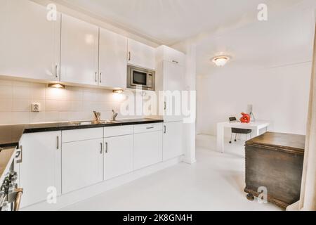 Fragment de l'intérieur de la lumière étroite cuisine maison avec style minimaliste mobilier blanc avec évier et cuisinière Banque D'Images