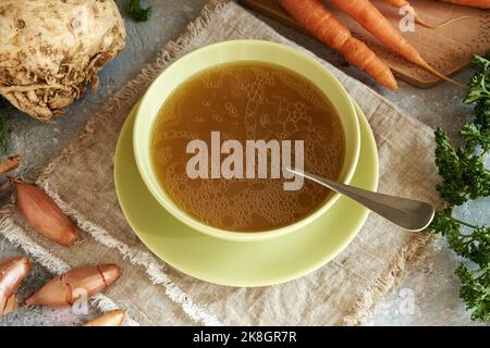 Bouillon d'os dans un bol à soupe avec carottes fraîches, oignons, persil et racine de céleri Banque D'Images