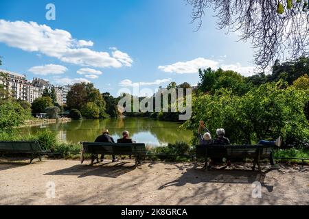 Parisiens bains de soleil sur les rives du lac du Parc Montsouris - Paris, France Banque D'Images